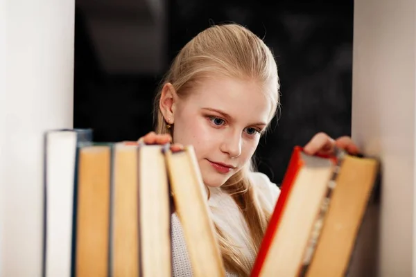 Bir kitaplıktaki genç kız — Stok fotoğraf