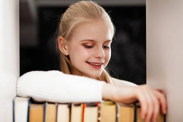 Tiener meisje in een bibliotheek — Stockfoto