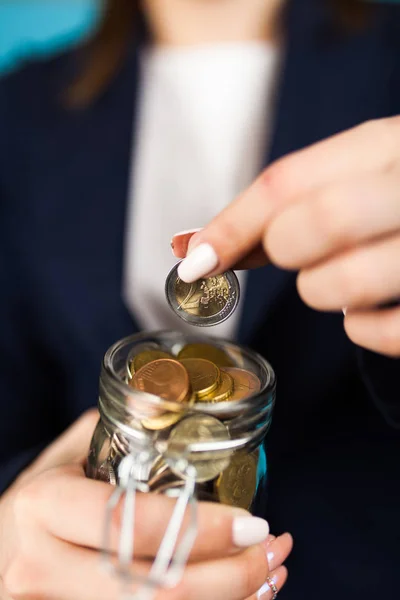 Mujer sosteniendo una moneda de 2 euros —  Fotos de Stock