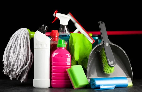 Cleaning supplies on black background — Stock Photo, Image