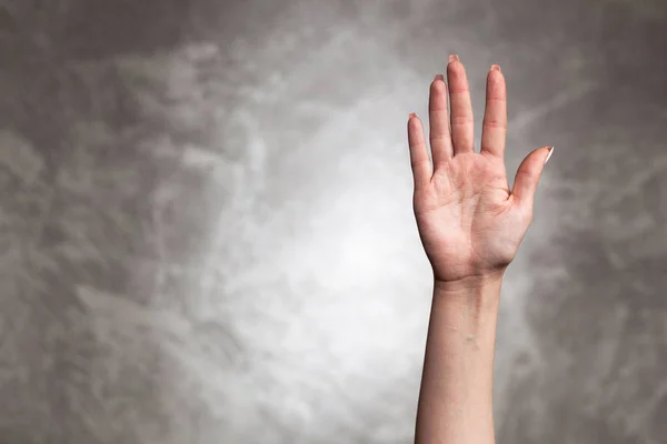 Weibliche Hand auf dunklem Hintergrund — Stockfoto