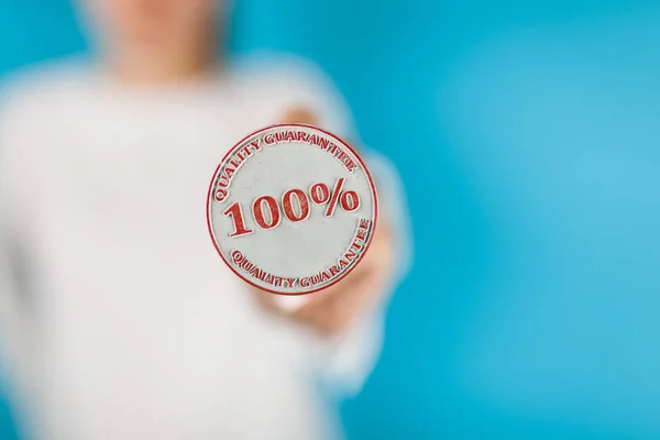 Woman holding hundred percent stamp