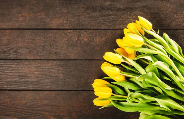 Желтые тюльпаны на деревянном фоне — стоковое фото