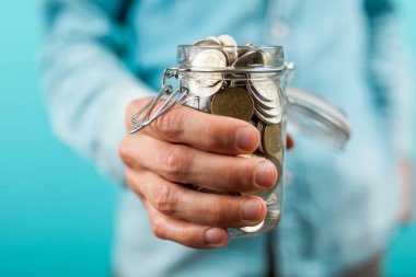 Bir madeni para kavanoz tutan adam