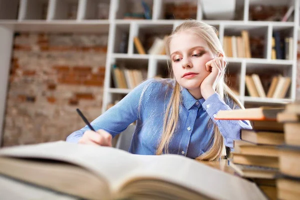 Tiener meisje in een bibliotheek — Stockfoto