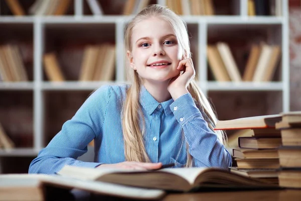 Tizenéves lány egy könyvtárban — Stock Fotó