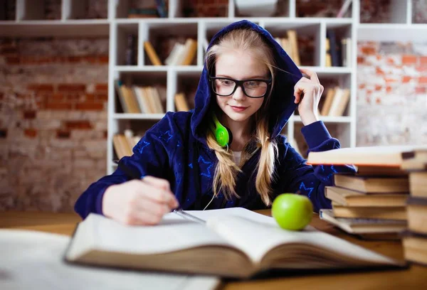 Tonårig flicka i ett bibliotek — Stockfoto