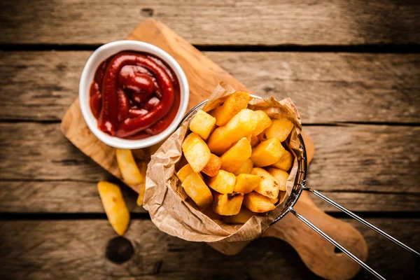 Pommes frites på träbord — Stockfoto