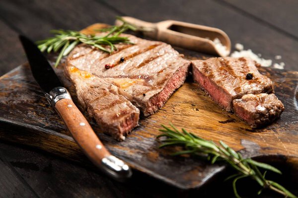 Grilled beef steak on a wooden cutting board