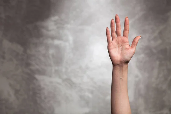 Vrouwelijke hand op donkere achtergrond — Stockfoto