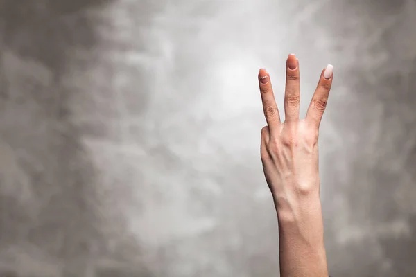 Weibliche Hand auf dunklem Hintergrund — Stockfoto