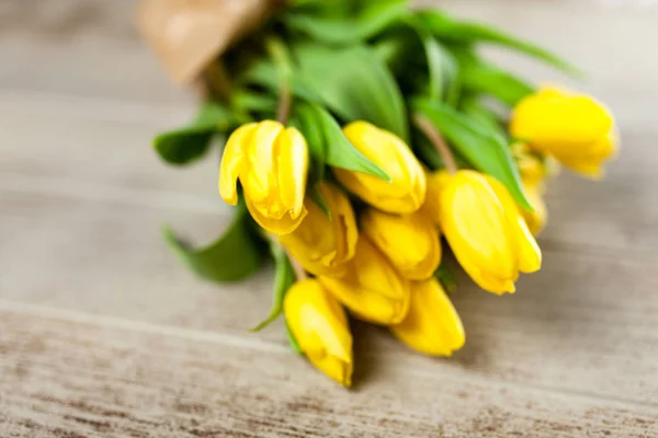 Желтые тюльпаны на деревянном фоне — стоковое фото