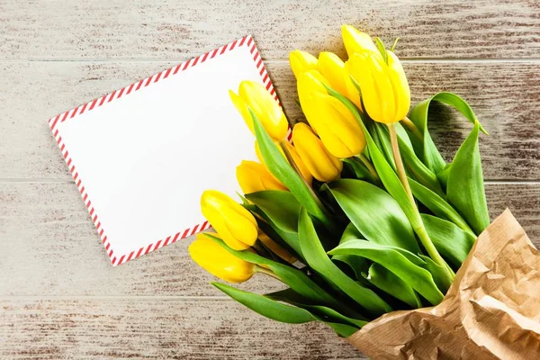A Letter and yellow tulips on wooden background — Stock Photo, Image