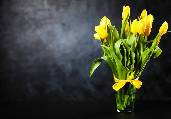 Желтые тюльпаны на темном фоне — стоковое фото
