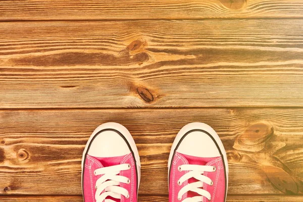 Roze sneakers op houten textuur — Stockfoto