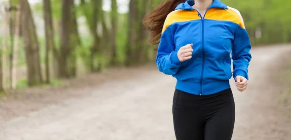 Joven hermosa mujer corriendo en un sendero — Foto de Stock