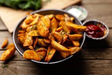 Ahşap masada fırında patates kızartması.