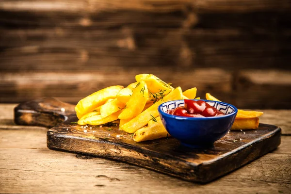 Batatas fritas na mesa de madeira — Fotografia de Stock