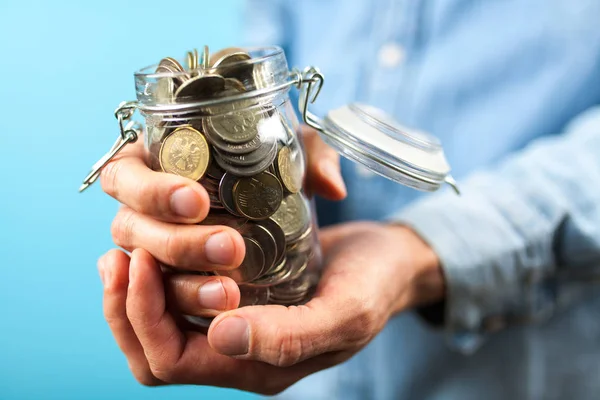 Man holding a coin jar — Stock Photo, Image