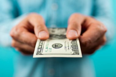 Bir yüz dolarlık banknot tutan adam