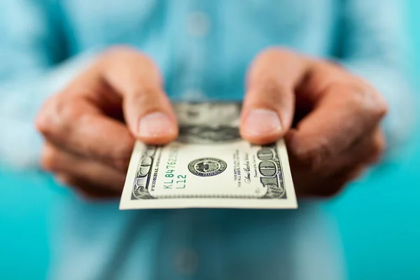 Hombre sosteniendo un billete de cien dólares —  Fotos de Stock