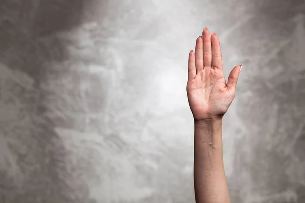 Weibliche Hand auf dunklem Hintergrund — Stockfoto