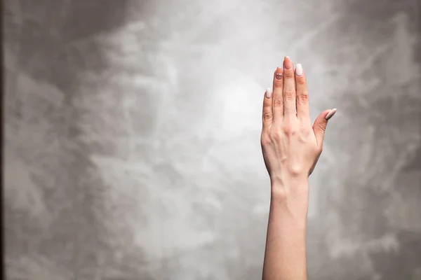 Weibliche Hand auf dunklem Hintergrund — Stockfoto