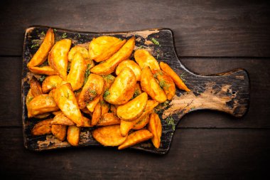 Ahşap masada fırında patates kızartması.