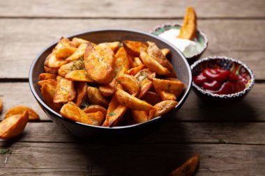 Ahşap masada fırında patates kızartması.
