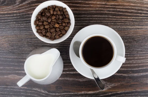 Coffee cup, jug milk and bowl with coffee beans