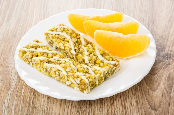 Granola bars with cereals and slices of orange in plate