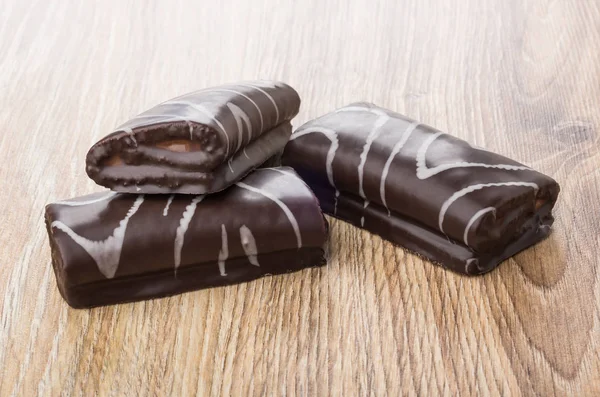 Three small chocolate swiss rolls on table