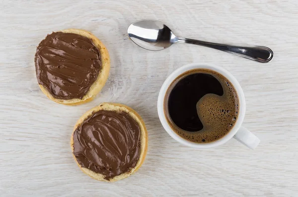 Sandwiches with nut-chocolate paste, coffee in cup and spoon