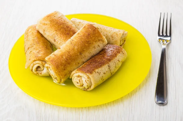Pancake rolls with stuffed in yellow plate and fork
