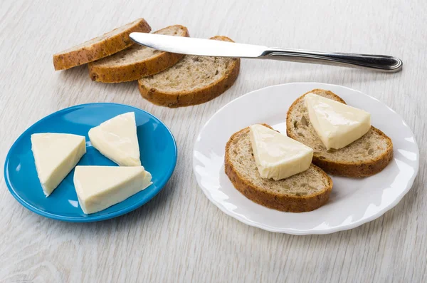Sandwiches with melted cheese, cheese in saucer, table knife, br