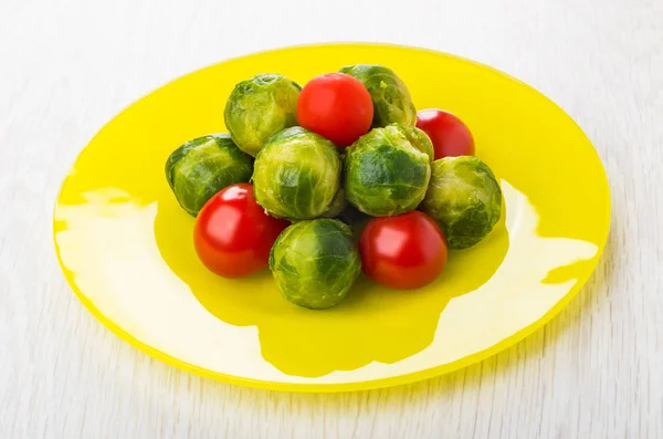 Cooked brussels sprouts with tomato cherry in yellow plate