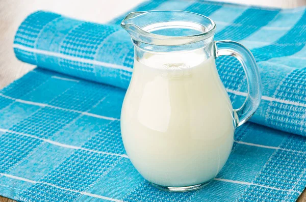 Milk in transparent pitcher on napkin