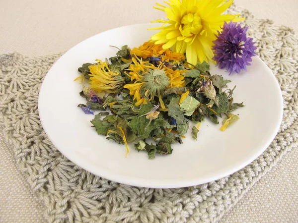 Herbal tea mix with flowers on a small plate — Stock Photo, Image