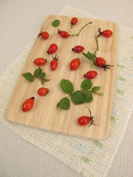 Rosa mosqueta de frutas silvestres sobre tabla de madera — Foto de Stock
