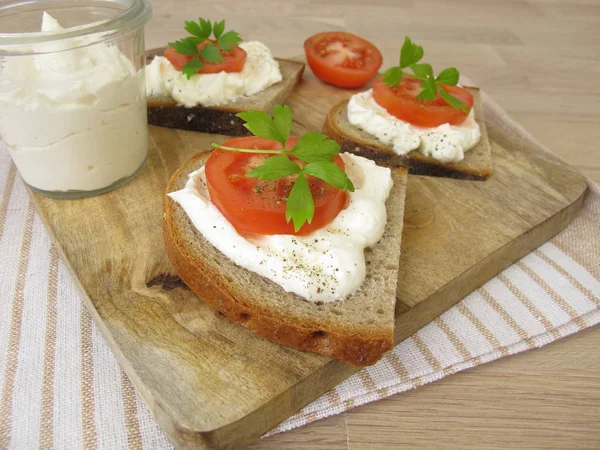 Brödbit med vispad fetaost grädde och tomat — Stockfoto