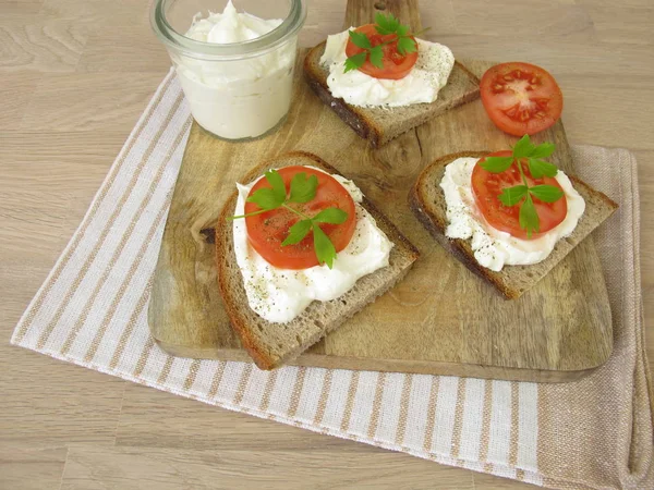 Piece of bread with whipped feta cream and tomato — Stock Photo, Image