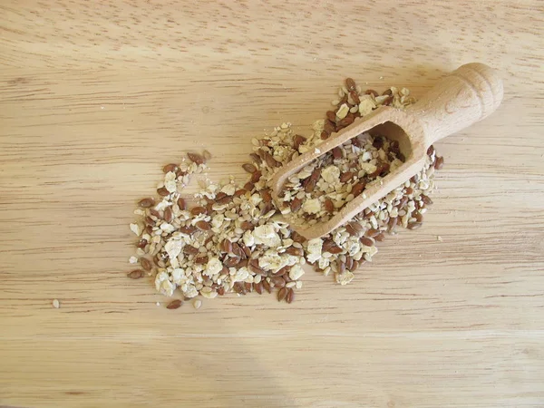 Mistura de sementes com aveia laminada, linhaça e sésamo em tábua de madeira — Fotografia de Stock