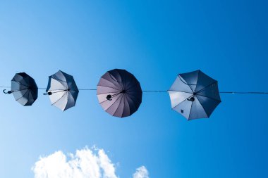 Mavi gökyüzüne karşı dizilmiş şemsiyeler