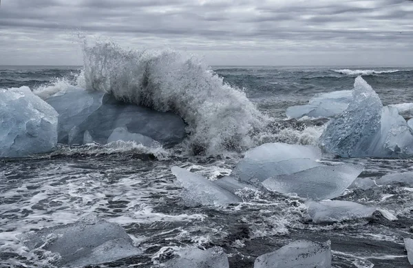 大块的冰从冰岛火山灰黑色海滩上冰川的咸水湖 冰慢慢融化在大海的波涛随着他们无情地崩溃他们 图库图片