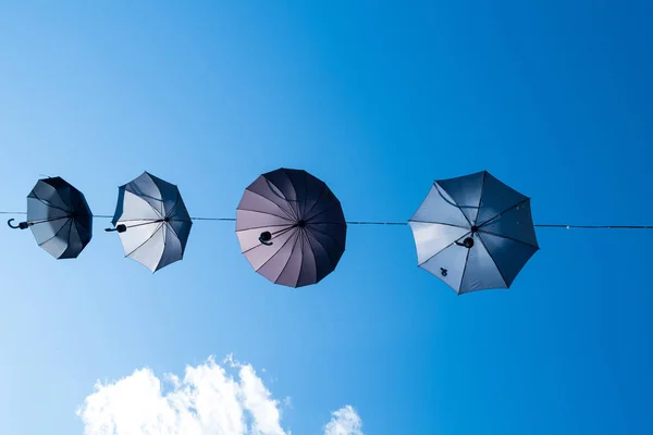 Umbrellas on a wire set against a blue sky — Stock Image Umbrellas Wire Set Blue Sky Stock Photo