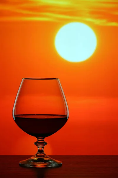 Brandy verre sur fond de coucher de soleil — Photo