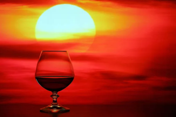 Brandy verre sur fond de coucher de soleil — Photo