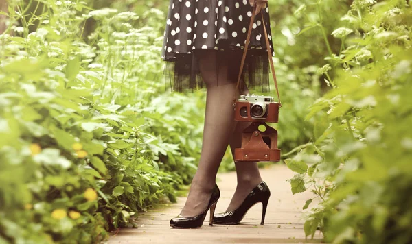 Camera and female legs — Stock Photo, Image