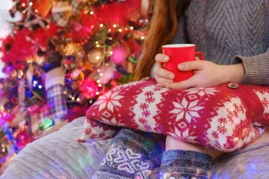 Kazaklı kadın otururken elinde bir kupa çay tutuyor.