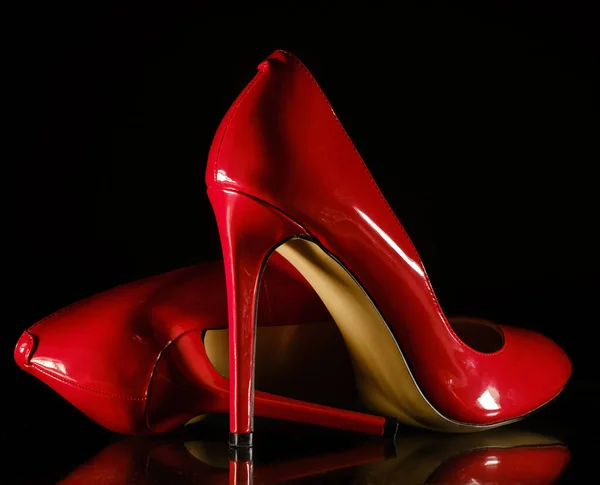 Lakleer glanzende vrouwelijke rode stiletto 's op een zwarte achtergrond — Stockfoto